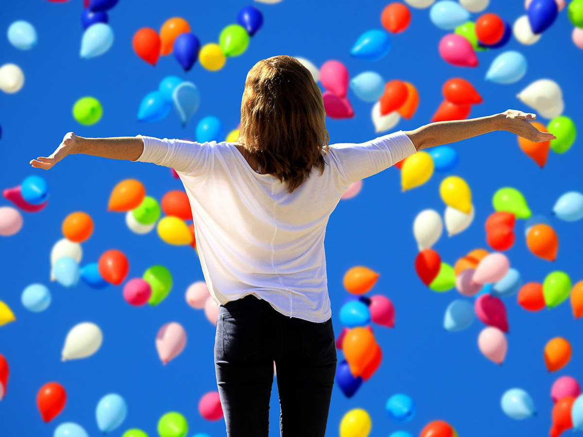 Gelukkige vrouw met ballonnen is assertief!